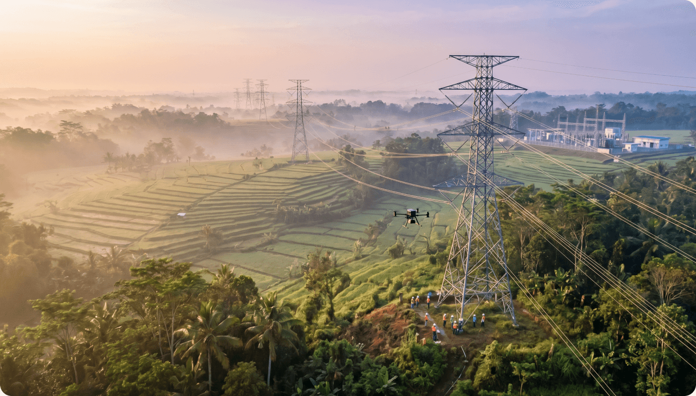 Aerial view of high-voltage transmission towers over Indonesian farmland